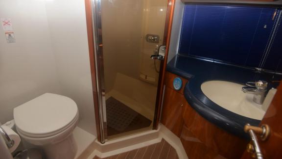 The bathroom on the motor yacht Act features a modern shower, toilet, and sink.